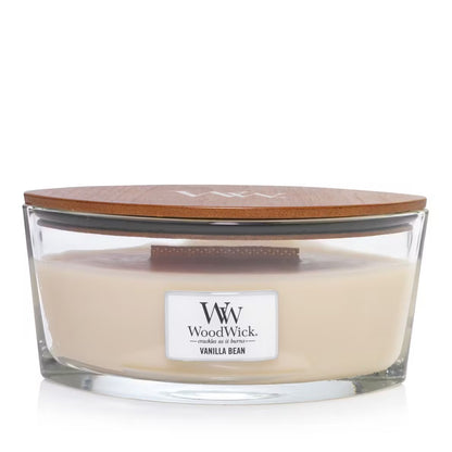 A clear ellipse-shaped jar candle with a brown wooden lid, labeled 'W. Woodwick Vanilla Bean'.