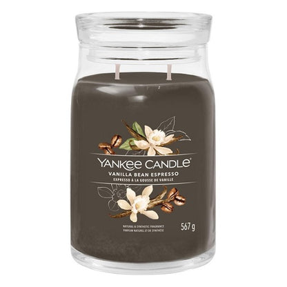 A Yankee Candle vanilla bean espresso candle in a clear glass jar with a brown label, showing the candle's weight of 550 grams.