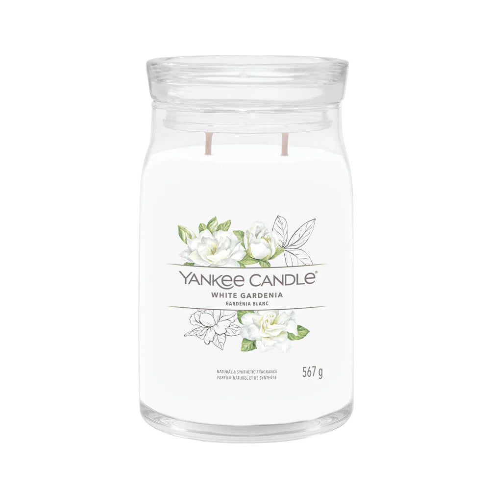 A clear cylindrical Yankee Candle with white gardenia design, with a wick at the bottom and a label that says 'White Gardenia' and 'Yankee Candle'. The candle is shown against a white background.