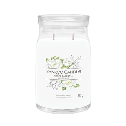 A clear cylindrical Yankee Candle with white gardenia design, with a wick at the bottom and a label that says 'White Gardenia' and 'Yankee Candle'. The candle is shown against a white background.