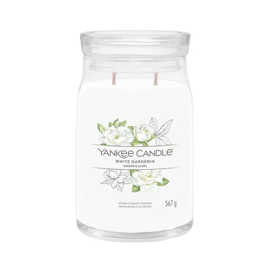 A clear cylindrical Yankee Candle with white gardenia design, with a wick at the bottom and a label that says 'White Gardenia' and 'Yankee Candle'. The candle is shown against a white background.