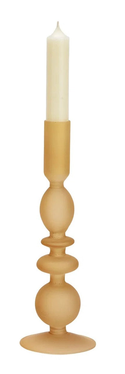 Yellow glass candle holder, with a white candle on top.