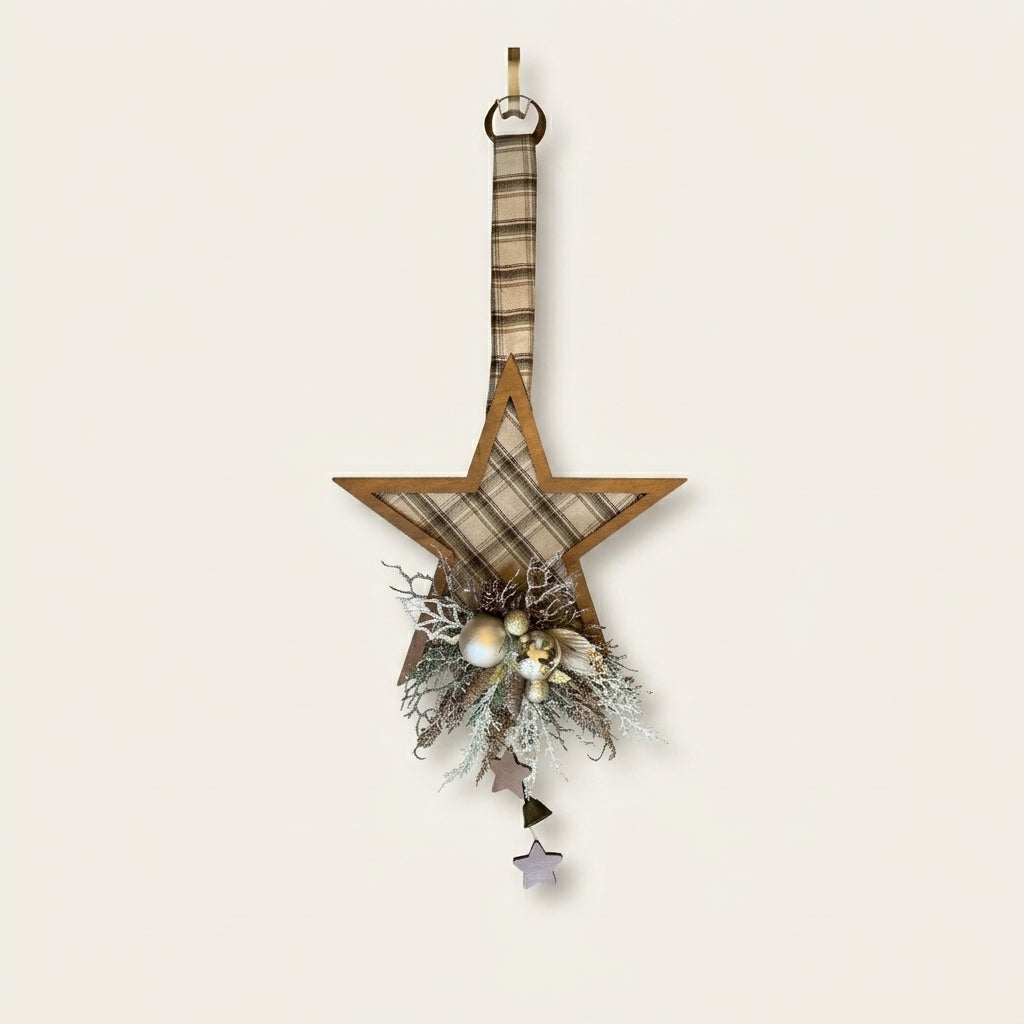 A rustic wooden star-shaped hanging ornament decorated with a beige and brown plaid fabric center, a hanging loop at the top, and a decorative cluster at the bottom featuring faux pine branches, small white berries, and dangling star charms.