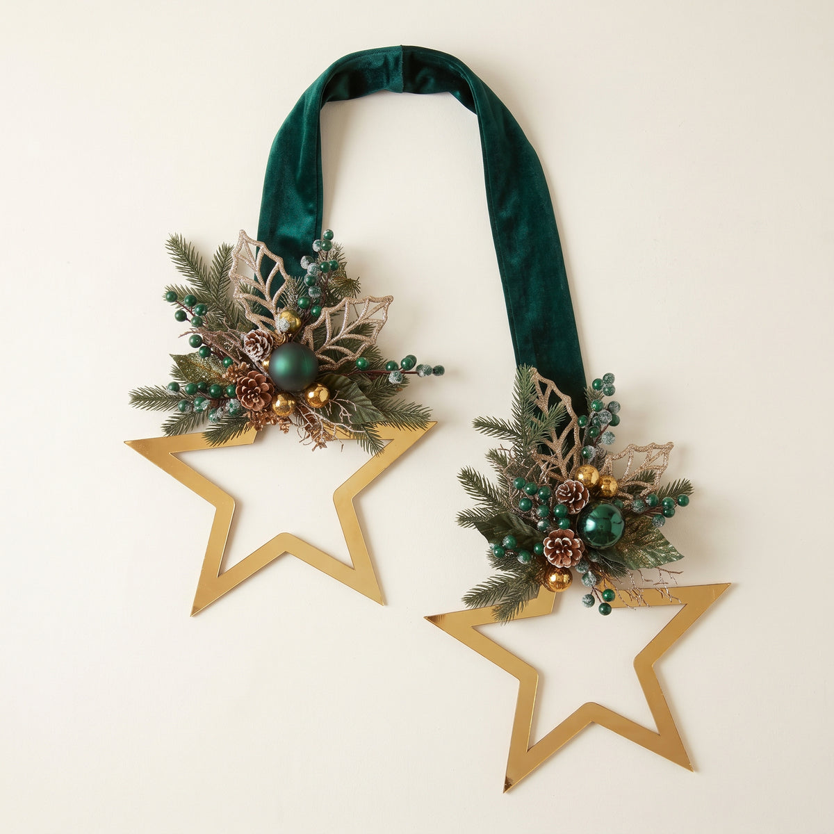 Handmade gold metallic double-sided star hanger for Christmas front door decor, designed by Inas, pictured against white nackground